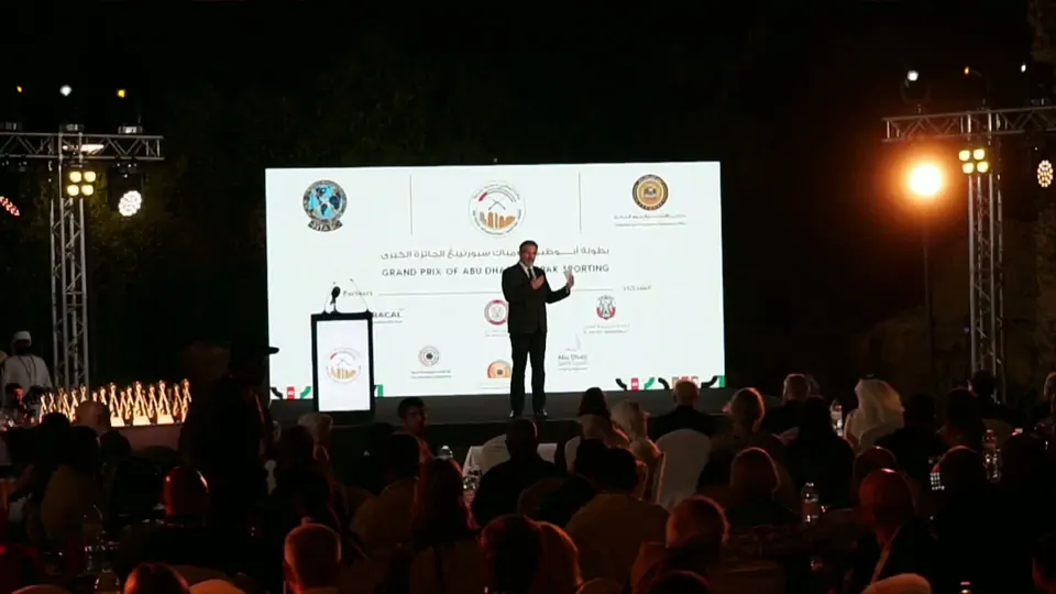 A wide shot from behind the audience towards the stage and LED screen at an outdoor awards gala we broadcast